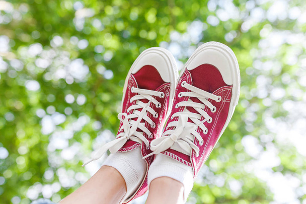 Un pied dans une baskets chaussures sur un fond de prk tree, Le concept de la mode et les jambes libres de varices
 - Photo, image