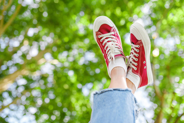 Bir spor ayakkabı ayakkabı prk ağaç arka plan, moda ve bacaklarda varis üzerinden ücretsiz kavramı üzerinde bir ayak - Fotoğraf, Görsel