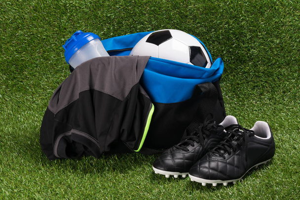 blue bag with a set for playing football on green grass - Foto, Imagem