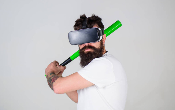 Sportsman mastering batting skills isolated on gray background. Bearded athlete using digital technology in training, sport concept. Gamer in VR glasses with hipster beard playing baseball online - Foto, afbeelding