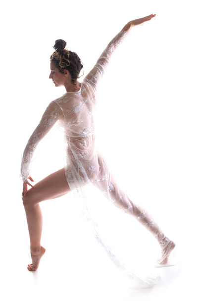 Lange slanke brunette dansen in een pure witte lace-wrap - Foto, afbeelding
