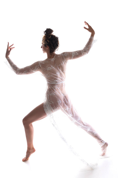 Vysoká štíhlá brunetka tančí v čiré bílé krajky zabalení - Fotografie, Obrázek