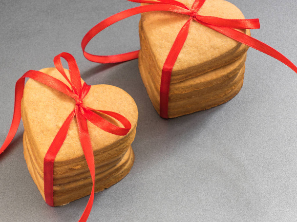 Homemade ginger biscuits in the shape of a heart tied with a red ribbon. Gift - Photo, Image