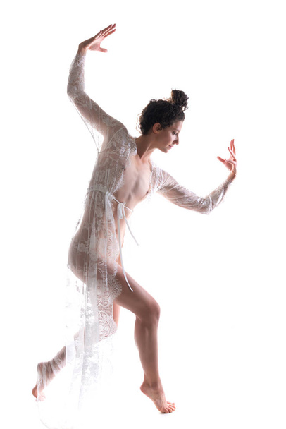 Tall slim brunette dancing in a sheer white lace wrap - Photo, Image