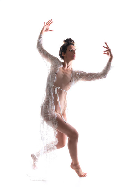 Tall slim brunette dancing in a sheer white lace wrap - Photo, Image