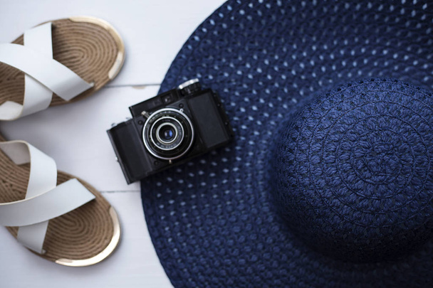 Summer background. Beach Travel vacation concept. Striped hat with shoes and camera   - 写真・画像