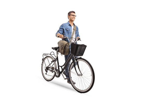 Full length portrait of a young man pushing a bicycle isolated on white background - 写真・画像