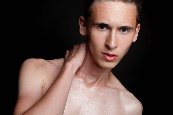 people, skincare and beauty concept - Wet young man with black hair on a black background. Portrait male with shaved chest . Men's skin care. Ripped muscular handsome man on black background - Фото, зображення