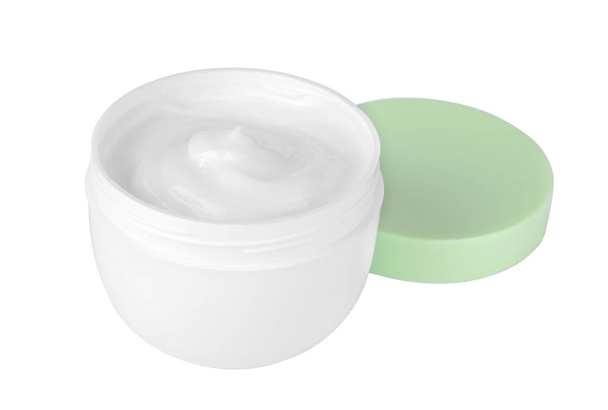 Crema facial en un frasco blanco con tapa verde sobre fondo blanco. aislado
 - Foto, Imagen