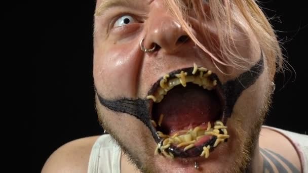Szaleństwo blond człowiek jedzenie larwy - Materiał filmowy, wideo