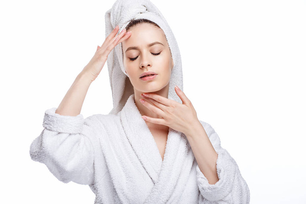 Mujer joven con albornoz y toalla en la cabeza, spa y retrato de cuidado, rostro natural limpio, retrato sobre un fondo blanco aislado
 - Foto, imagen