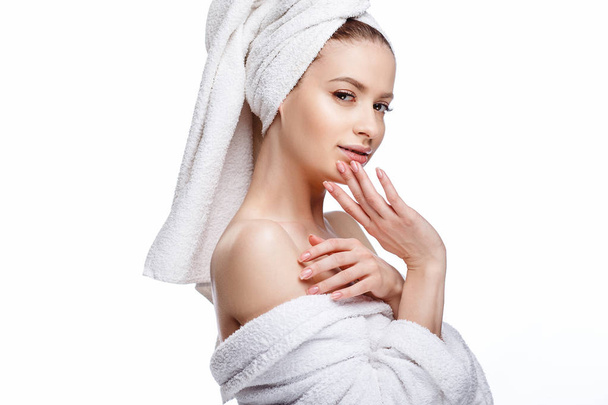Young woman in a bathrobe and towel on her head, spa and care portrait, clean natural face, portrait on a white background isolated - Fotó, kép