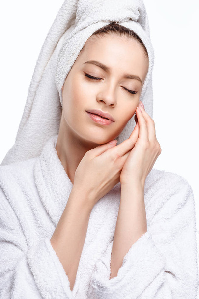 Young woman in a bathrobe and towel on her head, spa and care portrait, clean natural face, portrait on a white background isolated - 写真・画像
