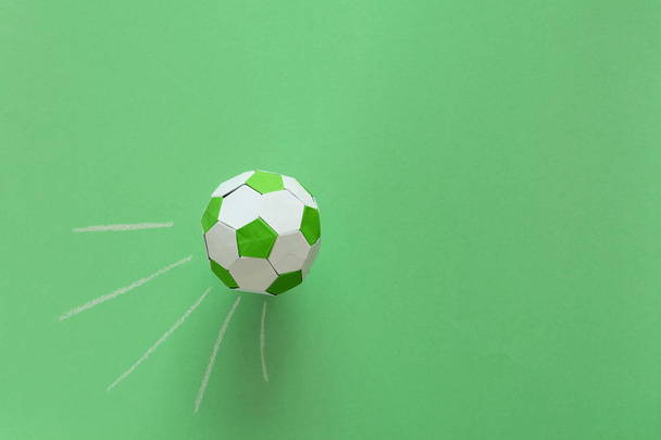 Paper soccer ball on soccer field or green background. Origami. Paper craft. Soccer game concept. - Fotoğraf, Görsel