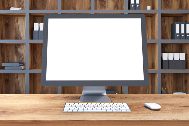 Computerbildschirm-Attrappen, die auf einem Holztisch in einem Raum mit einem Bücherregal im Hintergrund stehen. 3D-Rendering-Attrappe - Foto, Bild