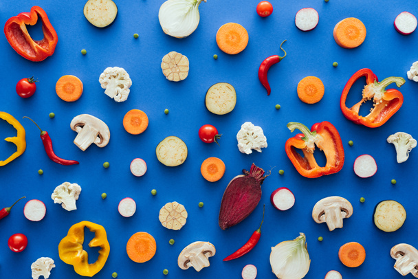 top view of fresh sliced healthy  vegetables on blue background  - Photo, Image