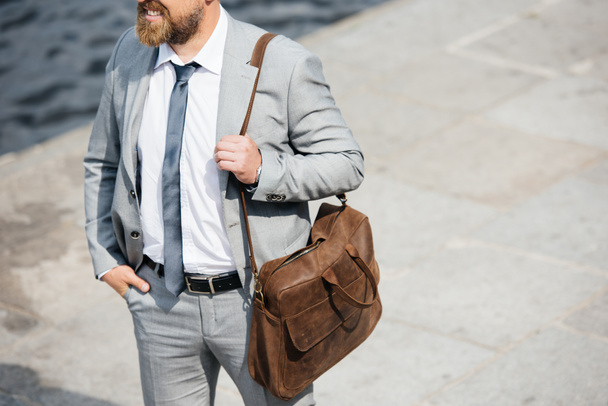 vista recortada de hombre de negocios con bolsa de cuero caminando en muelle
  - Foto, Imagen