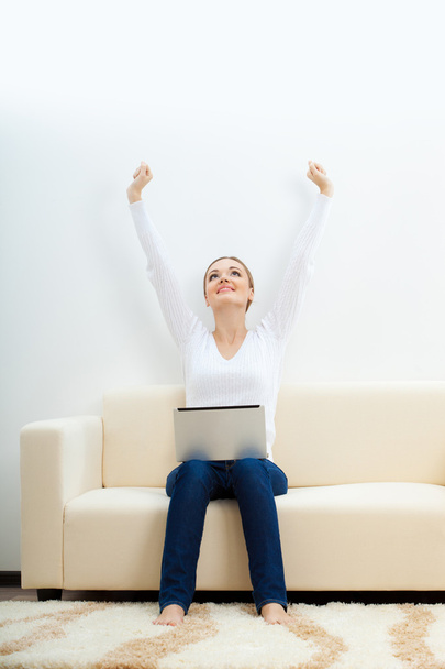 Happy woman sitting on sofa with laptop - Foto, imagen