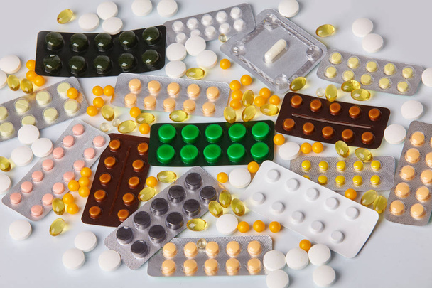 Diferentes paquetes coloridos de pastillas y tabletas sobre fondo blanco. Concepto de salud
.  - Foto, imagen
