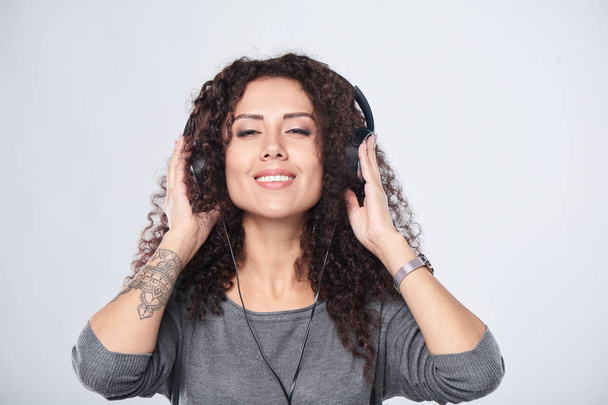 Woman listening to music in headphones - Φωτογραφία, εικόνα