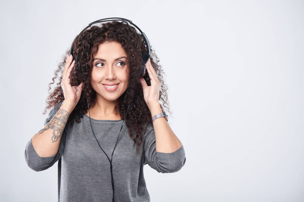 Woman listening to music in headphones - 写真・画像