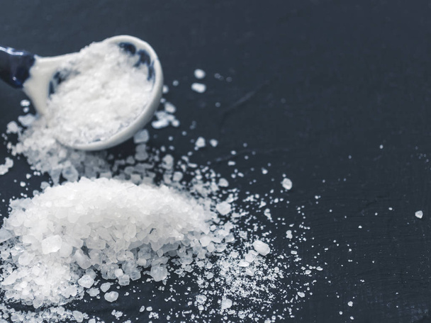 White salt in spoon on black background - Photo, image