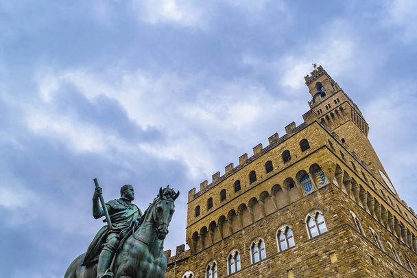 Low angle view of famous palazzo vecchio building and cosimo I sculpture in Florence, Italy - Photo, image