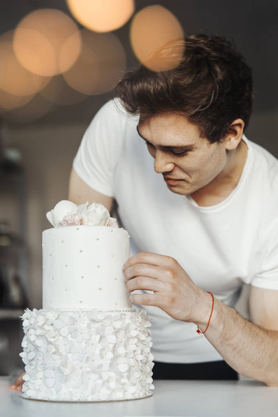 Young attractive man decorating cake - Zdjęcie, obraz
