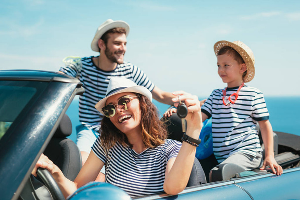 Happy family travel and having fun in cabriolet car near sea - Photo, Image