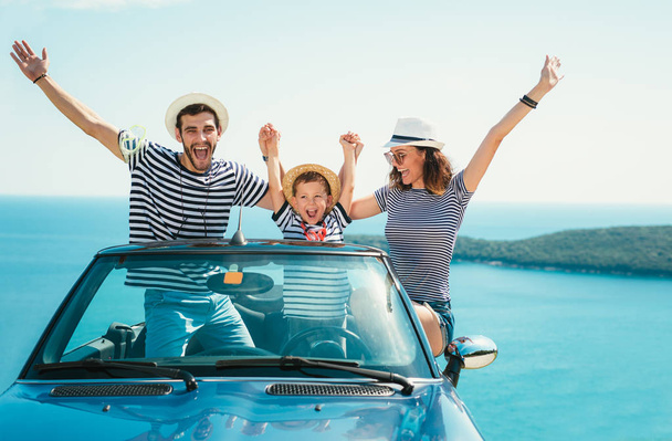 Ευτυχισμένη οικογενειακή διασκέδαση ταξίδια και έχοντας στο καμπριολέ αυτοκίνητο κοντά στη θάλασσα - Φωτογραφία, εικόνα