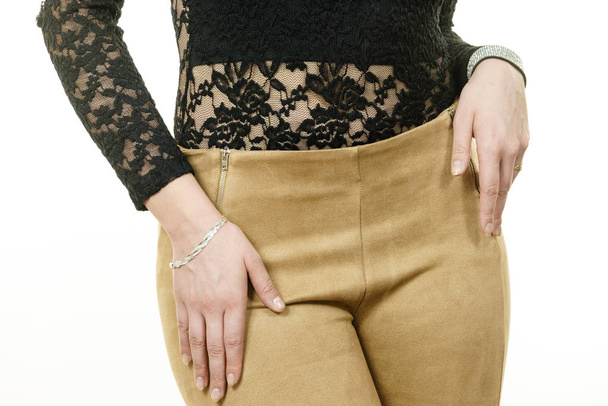 Close up of fashion model outfit details. Female wearing brown suede trousers and lace top. - 写真・画像
