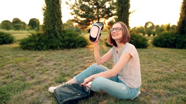 Cheerful young girl in glasses uses a VR glasses in the evening. - Filmagem, Vídeo