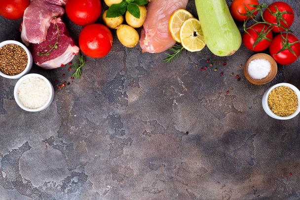 Rahmen der gesunden Ernährung Saubere Ernährung Auswahl einschließlich bestimmter Proteine beugt Krebs vor: Fleisch, Gewürze, Gemüse, Getreide auf dunklem Steinboden, flache Lage und Kopierraum - Foto, Bild