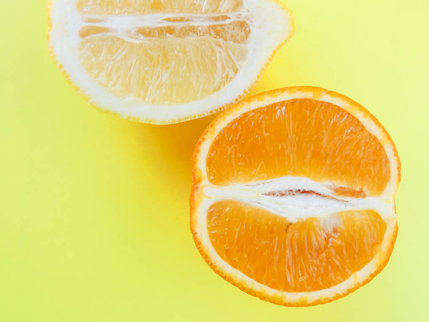 Orange and lemon close-up against a yellow background - Foto, Imagem