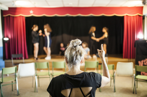 girls praising a theater class before the look of her blonde teacher on her back - Photo, Image