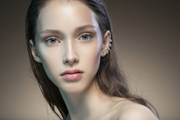 Young woman with natural makeup and stylish accessories in ear  - Φωτογραφία, εικόνα