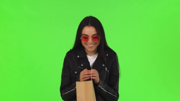 Όμορφη νεαρή γυναίκα που ψάχνει μέσα την τσάντα για ψώνια - Πλάνα, βίντεο