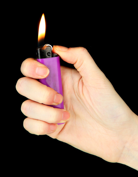 Burning lighter in female hand, isolated on black - Photo, image