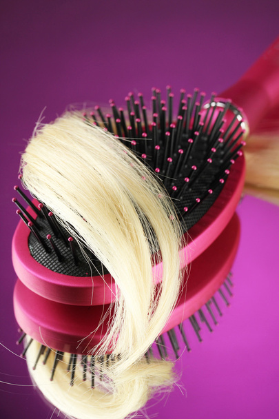 Comb brush with hair on purple background - Fotoğraf, Görsel