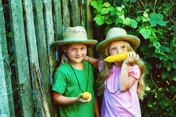 Śmieszne dzieci w przyrodzie gospodarstwa gotowanej kukurydzy - Zdjęcie, obraz