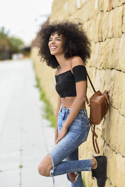 Szczęśliwy mieszane kobieta z afro włosów śmiejąc się na zewnątrz. Kobieta na sobie ubranie w tła miejskiego. Koncepcja życia - Zdjęcie, obraz