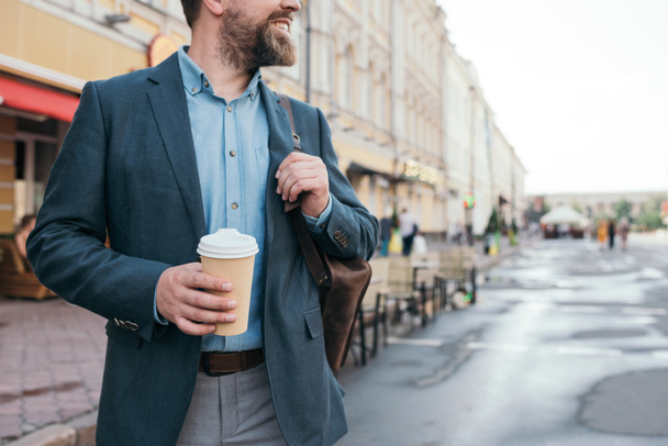 Обрезанный вид человека с кофе, чтобы гулять по городу
 - Фото, изображение