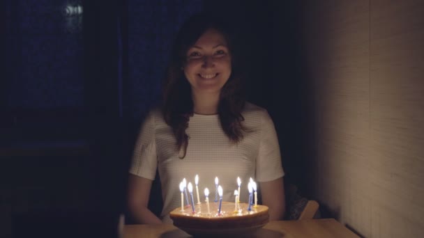 junge Frau pustet Kerzen auf Festtagstorte aus - Filmmaterial, Video