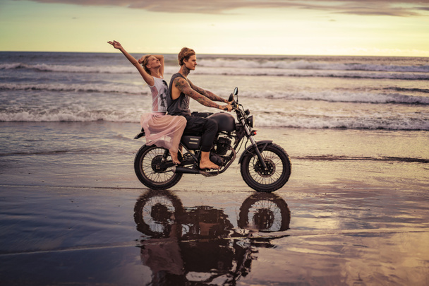boldog barátom és a barátnője, lovaglás motorkerékpár ocean beach alatt napkelte - Fotó, kép