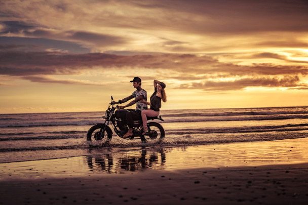 Affectionate pary jazda konna motocykl na ocean plaża  - Zdjęcie, obraz
