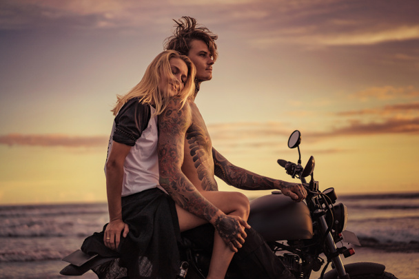 Szczęśliwa dziewczyna pochylony na ramieniu chłopaka na motocykl na ocean plaża  - Zdjęcie, obraz