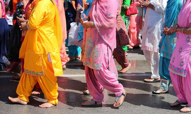 femmes sikhs pieds nus vêtus de vêtements traditionnels colorés lors d'une célébration religieuse
 - Photo, image