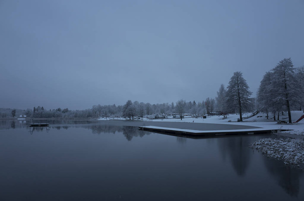 Piękne zdjęcia przyrody i krajobrazu niebieski Zmierzch wieczorny w Katrineholm Skandynawia Szwecja. Las i jezioro z lodu i śniegu. - Zdjęcie, obraz