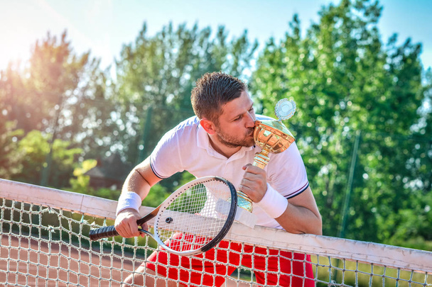 tennis player with golden goblet - Fotó, kép