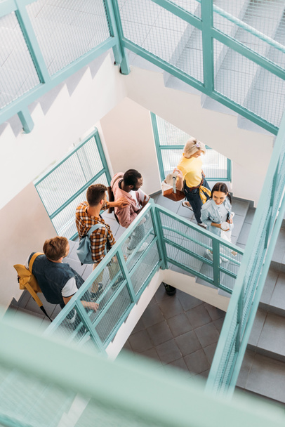 visão de alto ângulo do grupo de jovens estudantes descendo escadas na faculdade
 - Foto, Imagem